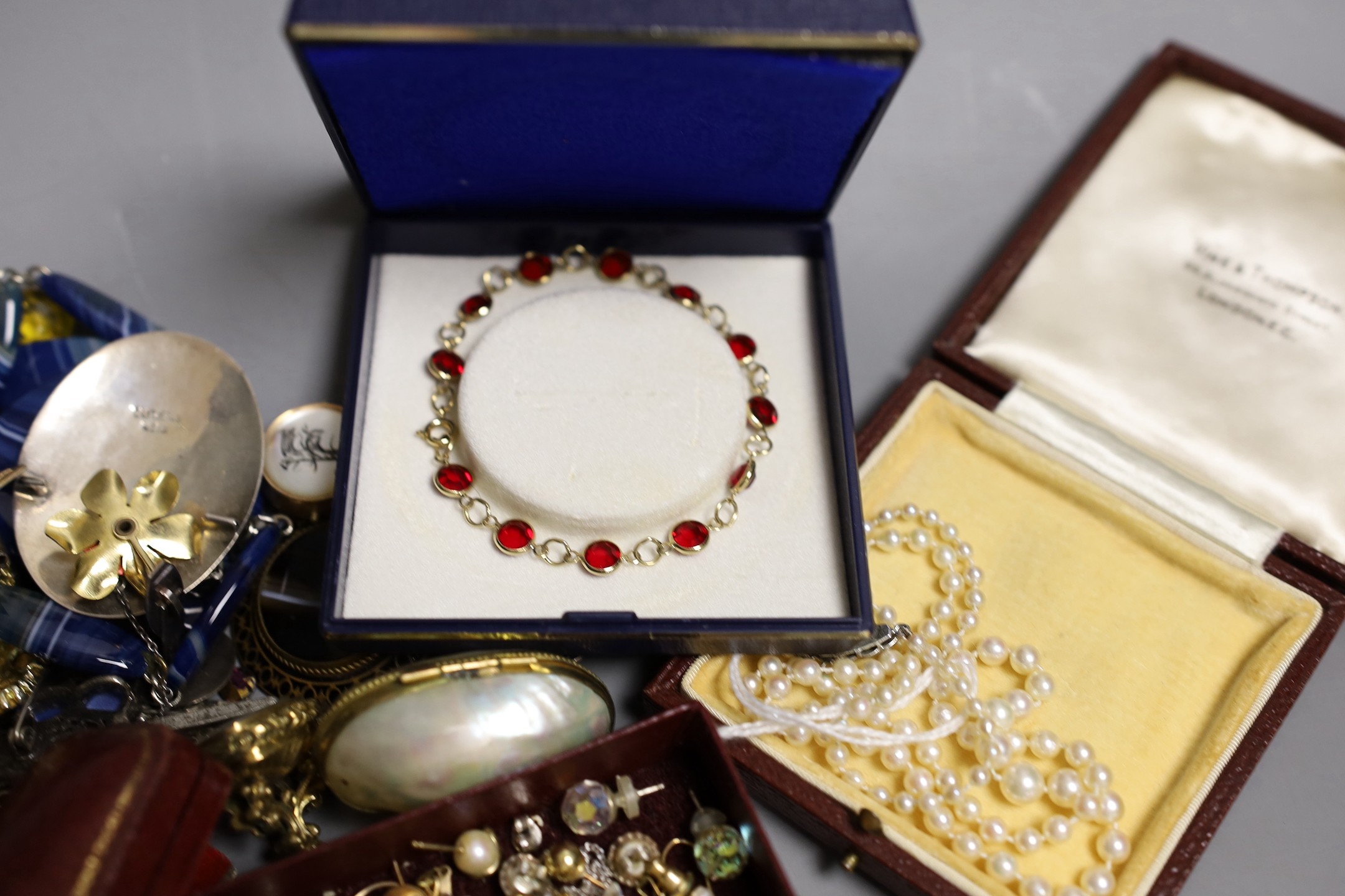 A group of assorted costume jewellery including a single strand pearl necklace